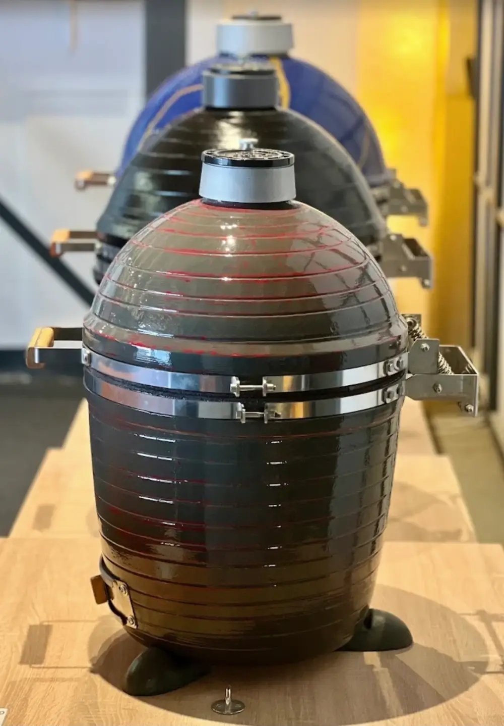 Barbecues en céramique dans le showroom | L'ATELIER DU BBQ Barbecues en céramique alignés dans un showroom.